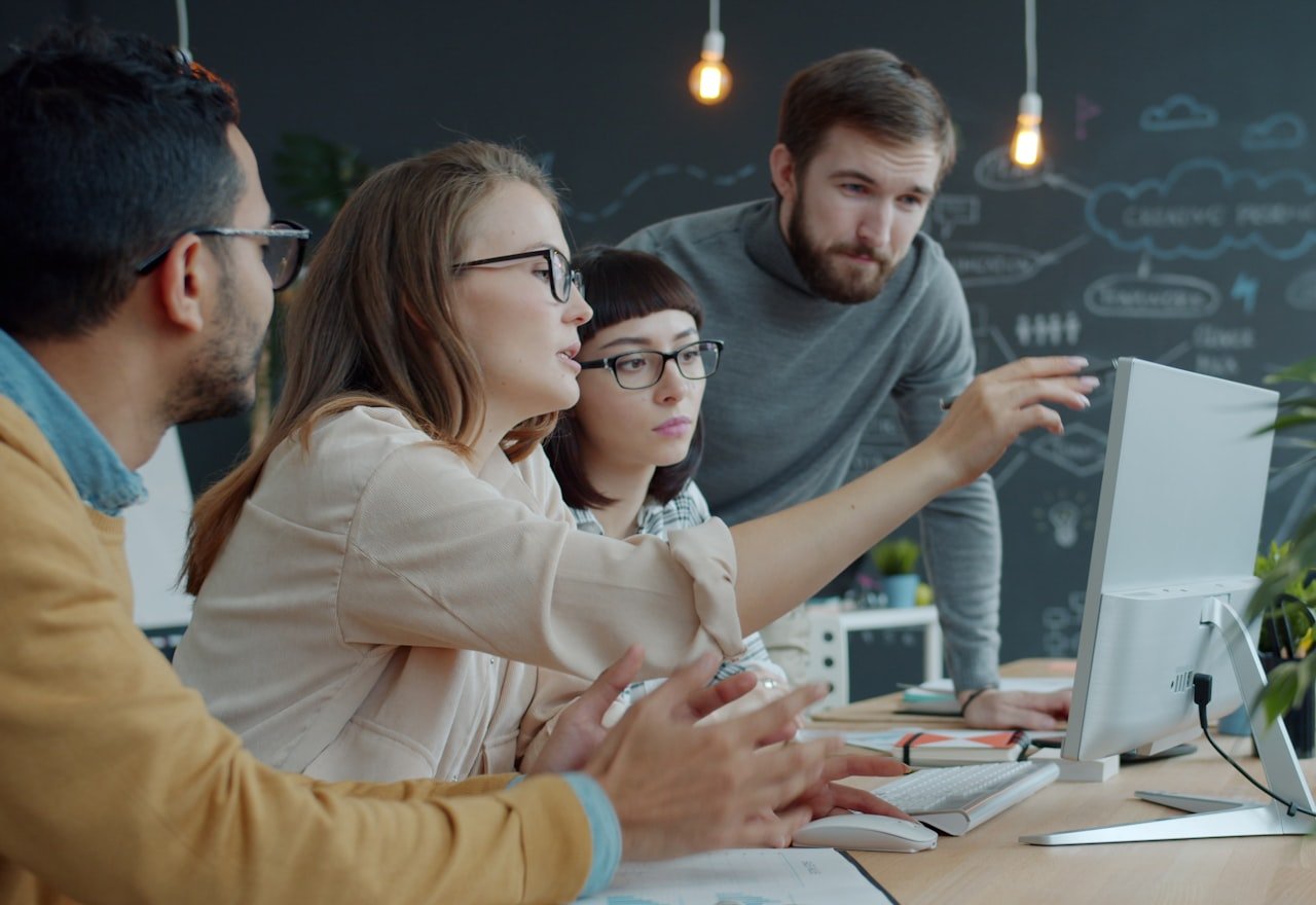 A team gathered around a screen, talking through a piece of work