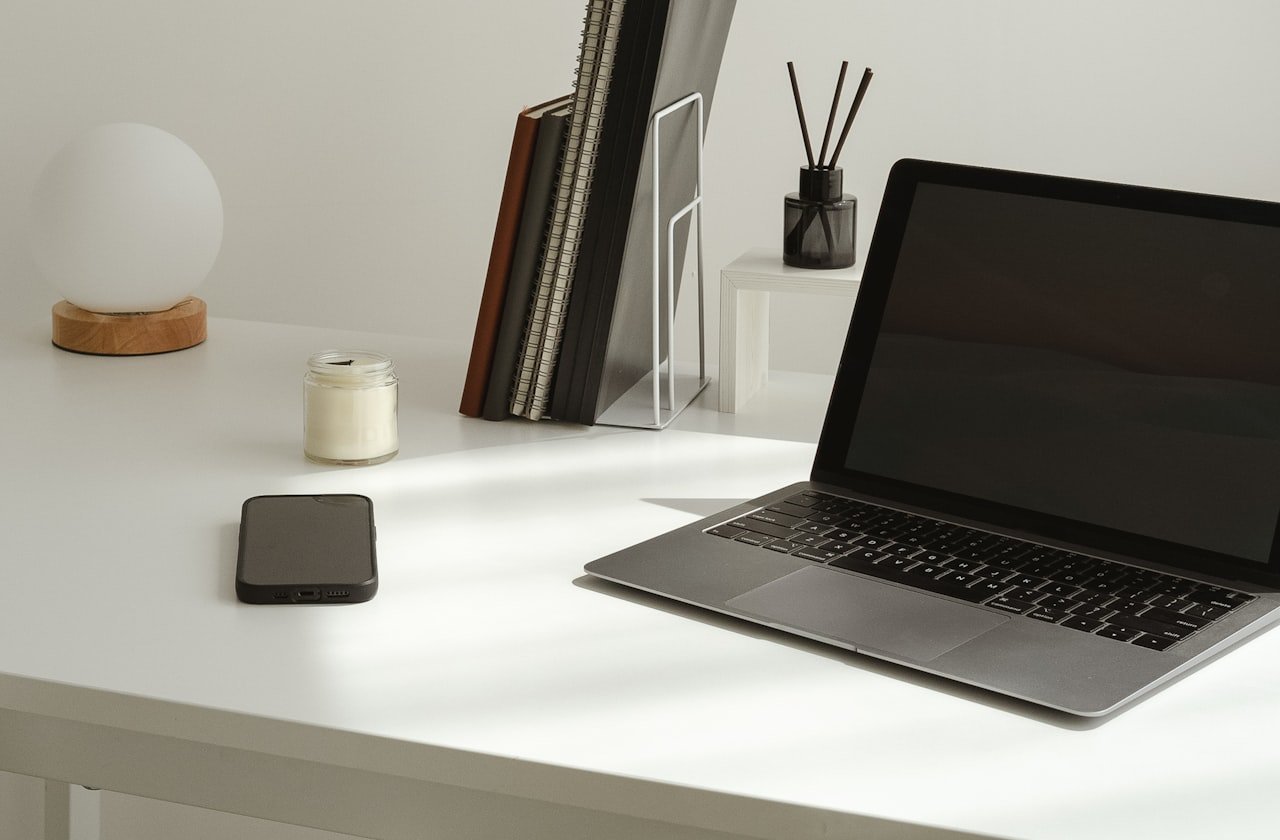 A laptop and notebooks on a clean, minimal desk